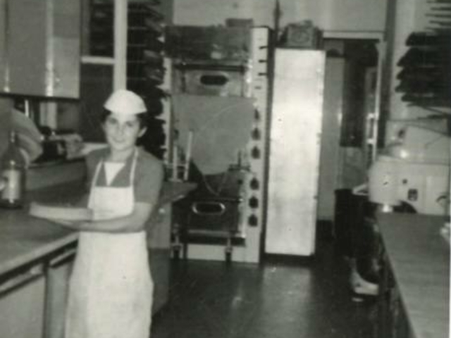 immagine antica di un giovane pasticcere nel laboratorio di una pasticceria