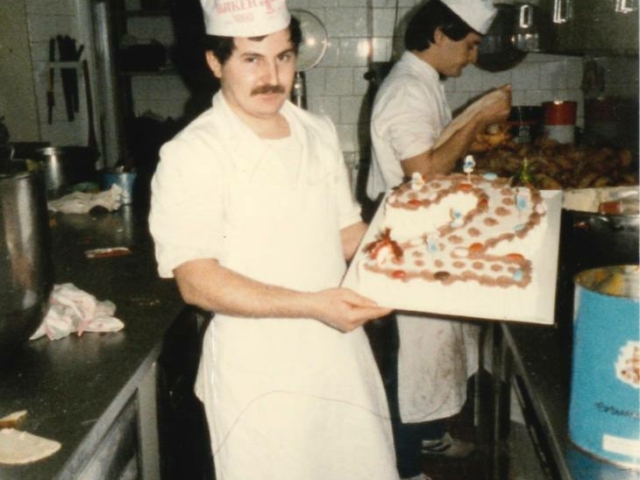 pasticciere che mostra una torta realizzata per un compleanno di due anni